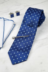 Blue silk patterned tie displayed with matching cufflinks and pocket square.
